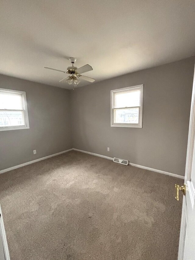 carpeted spare room with ceiling fan