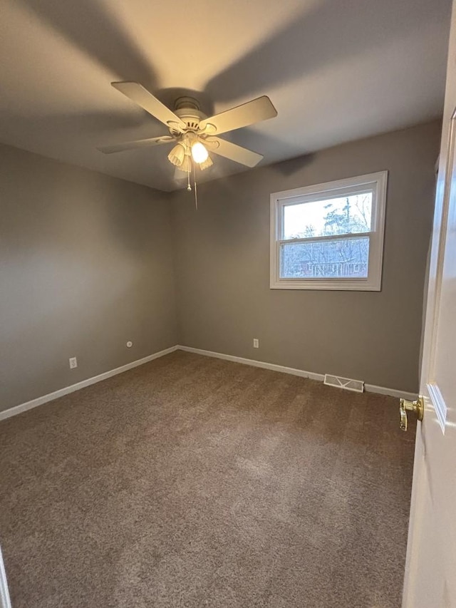 carpeted spare room featuring ceiling fan