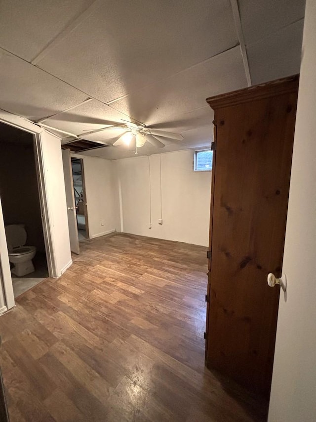 basement featuring ceiling fan and wood-type flooring