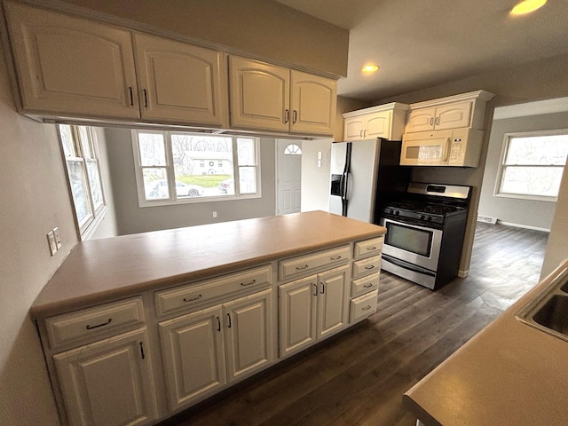 kitchen with dark hardwood / wood-style floors, stainless steel range with gas cooktop, and sink