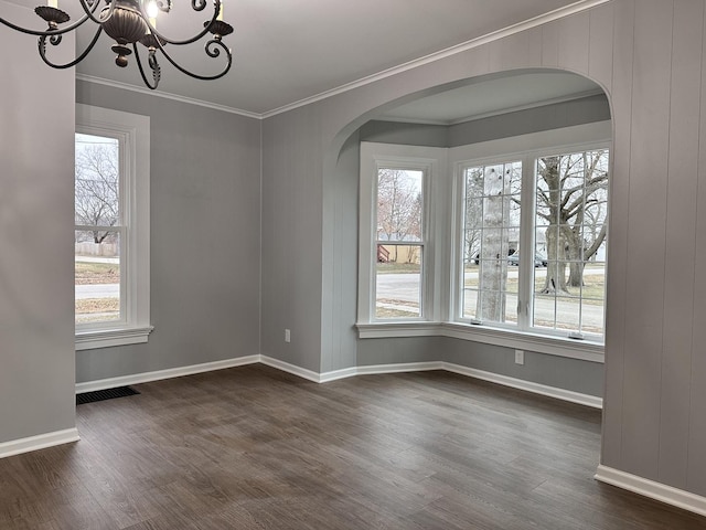 unfurnished dining area with crown molding, dark wood-type flooring, and a notable chandelier