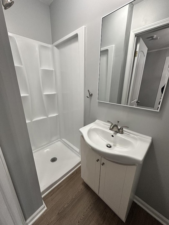 bathroom featuring a shower, vanity, and wood-type flooring