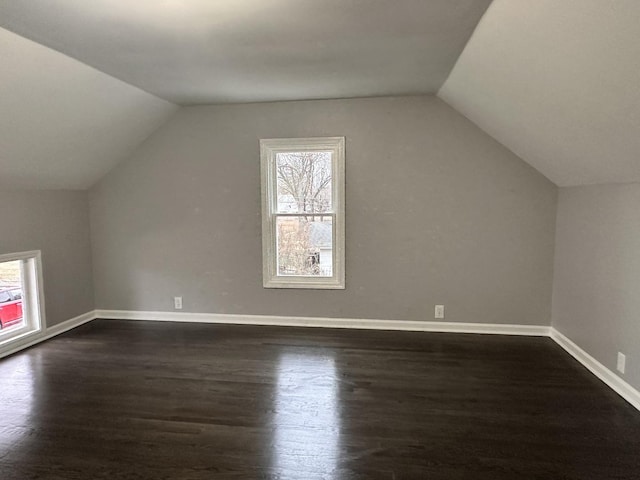 bonus room with a healthy amount of sunlight, dark hardwood / wood-style floors, and lofted ceiling