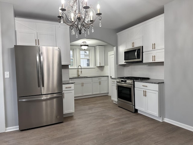 kitchen with tasteful backsplash, white cabinetry, sink, and stainless steel appliances