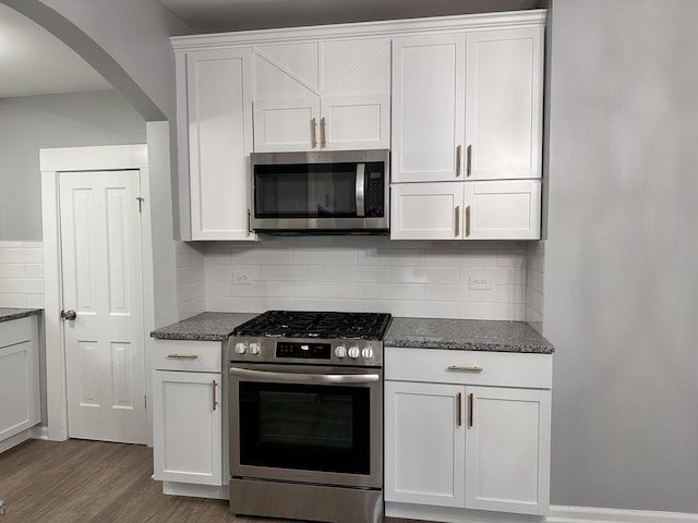 kitchen featuring backsplash, white cabinetry, dark wood-type flooring, and stainless steel appliances