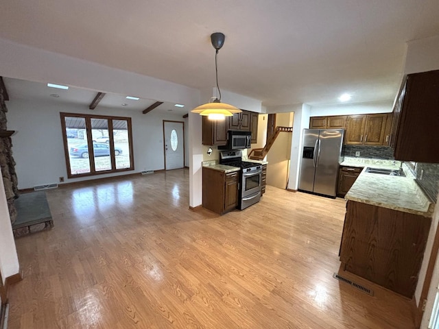 kitchen with tasteful backsplash, stainless steel appliances, sink, beamed ceiling, and light hardwood / wood-style floors