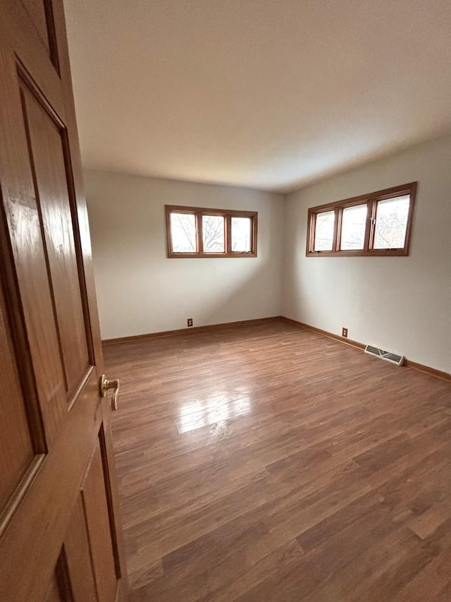 empty room with hardwood / wood-style flooring