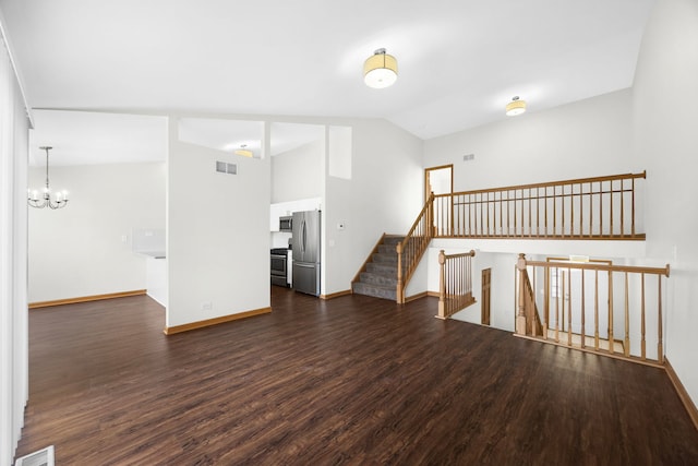 empty room featuring dark hardwood / wood-style flooring, lofted ceiling, and a notable chandelier