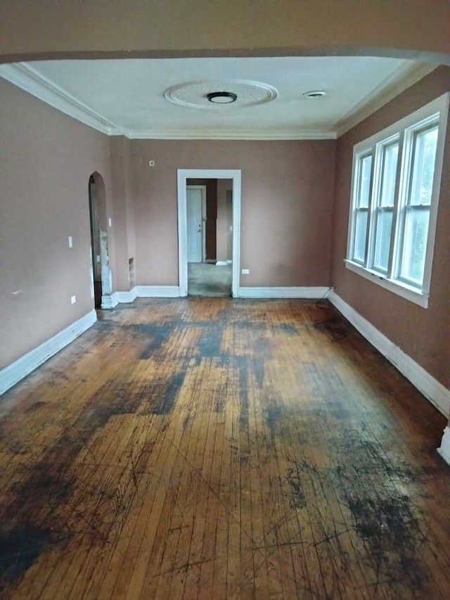 spare room with dark hardwood / wood-style flooring and crown molding