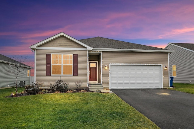 ranch-style home with cooling unit, a garage, and a yard