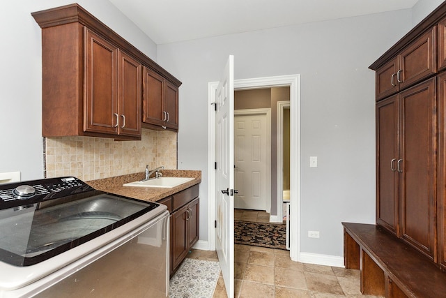 kitchen with decorative backsplash, range with electric stovetop, and sink