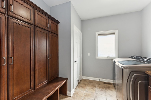 washroom featuring light tile patterned floors, cabinets, and independent washer and dryer