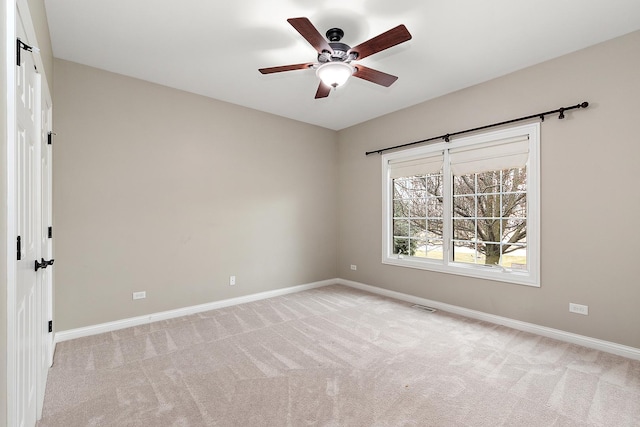 spare room featuring light colored carpet and ceiling fan