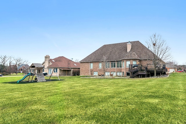 back of property with a playground, a wooden deck, cooling unit, and a lawn