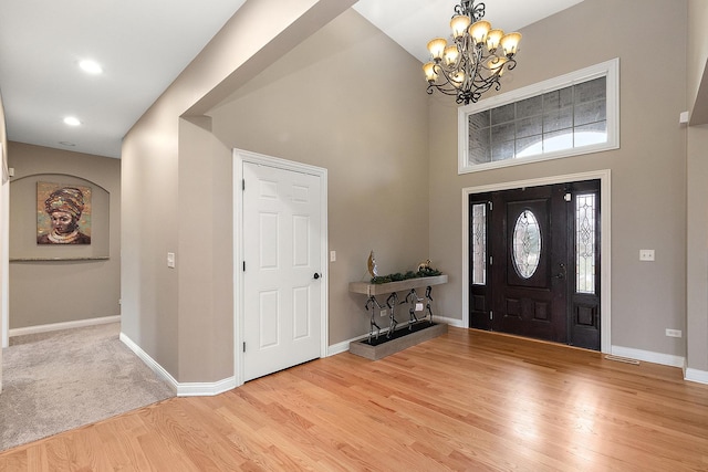 foyer with a notable chandelier, a high ceiling, and light wood-type flooring