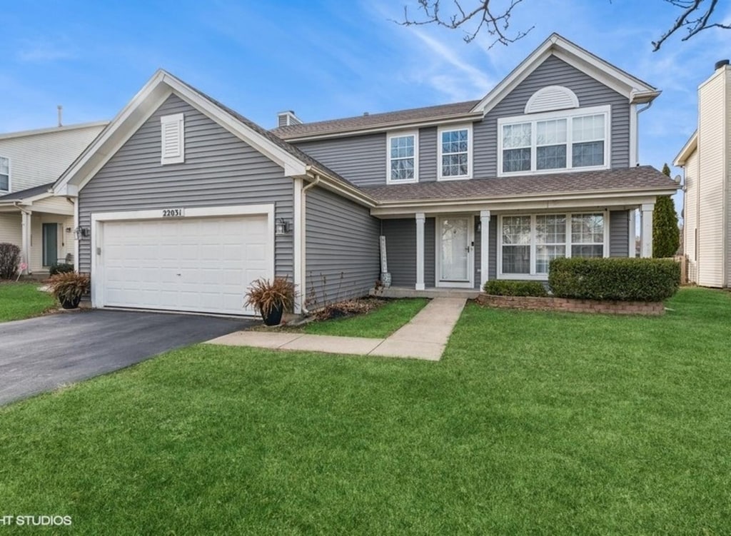 front of property with a front yard and a garage