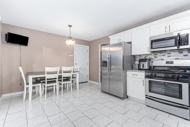 kitchen with light stone countertops, appliances with stainless steel finishes, tasteful backsplash, pendant lighting, and white cabinets