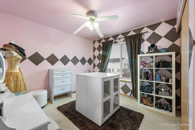 walk in closet with light carpet and ceiling fan