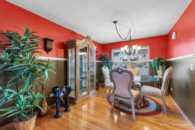 dining room featuring hardwood / wood-style floors and a notable chandelier