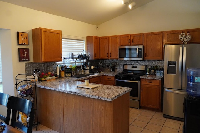 kitchen with dark stone counters, vaulted ceiling, decorative backsplash, kitchen peninsula, and stainless steel appliances