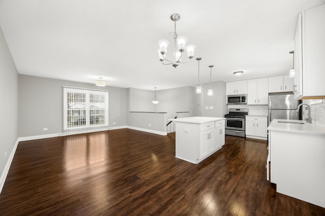 kitchen featuring stainless steel appliances, dark wood-type flooring, a kitchen island, pendant lighting, and white cabinets