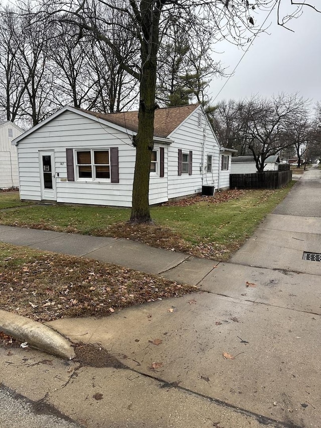 view of side of home with a lawn and cooling unit