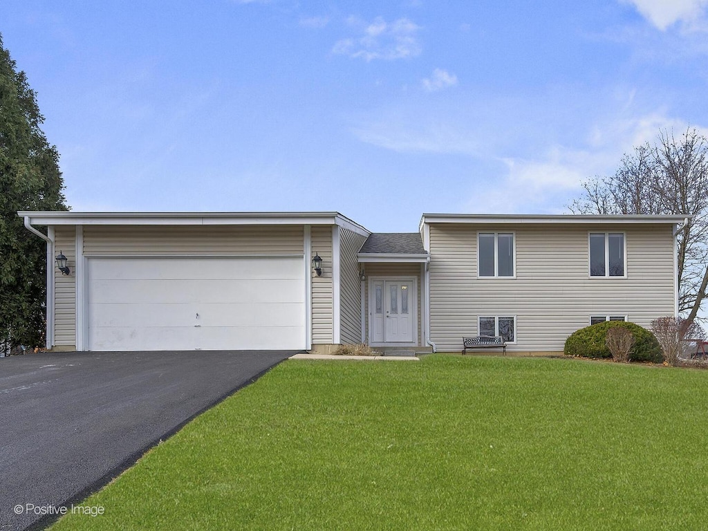 view of front of property with a front yard and a garage