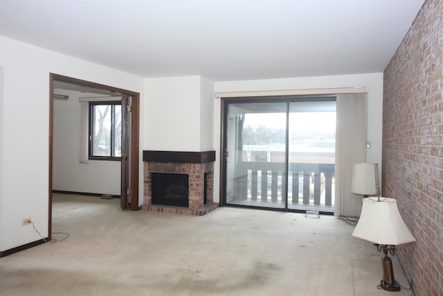 unfurnished living room with light carpet, a fireplace, and brick wall