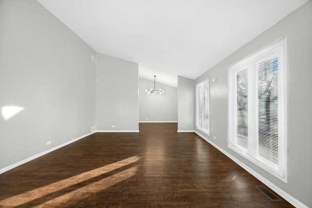 unfurnished living room featuring dark hardwood / wood-style floors, vaulted ceiling, and plenty of natural light