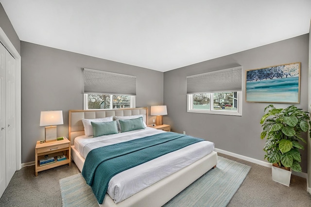 carpeted bedroom featuring multiple windows and a closet