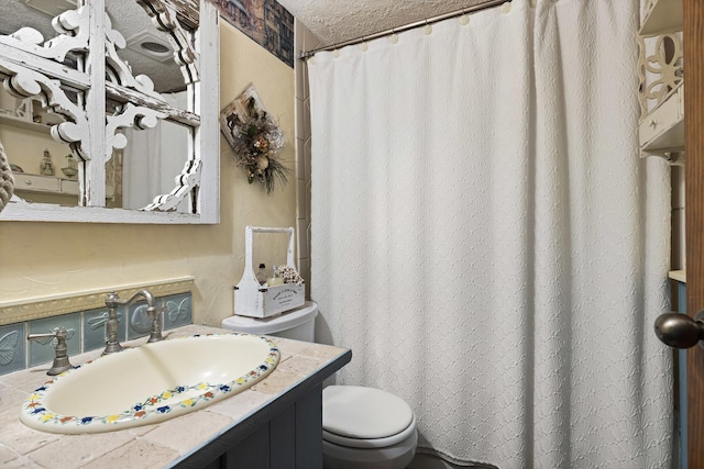 bathroom featuring vanity, a textured ceiling, and toilet