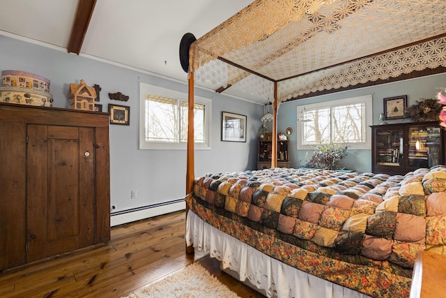 bedroom featuring beam ceiling, hardwood / wood-style flooring, ornamental molding, and a baseboard heating unit