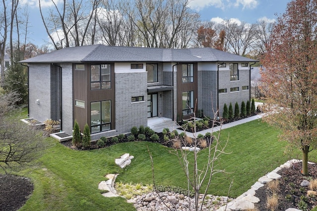 view of front of home featuring a front lawn and brick siding