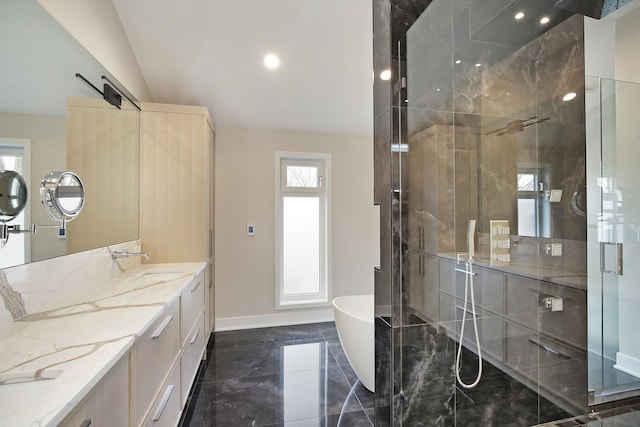 bathroom featuring baseboards, vaulted ceiling, a freestanding bath, vanity, and a shower stall