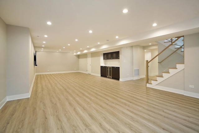 finished basement with light wood-type flooring, baseboards, visible vents, and recessed lighting