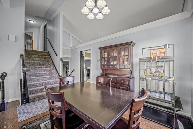 dining room with dark wood-type flooring, lofted ceiling, and an inviting chandelier