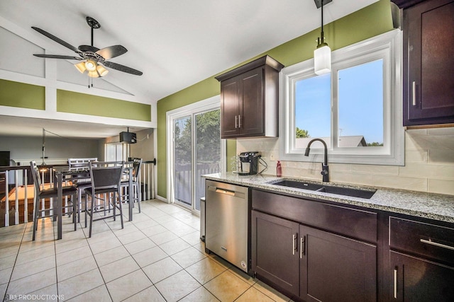 kitchen featuring dishwasher, sink, tasteful backsplash, light stone counters, and vaulted ceiling