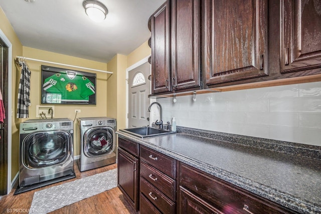 washroom featuring independent washer and dryer, sink, cabinets, and light wood-type flooring