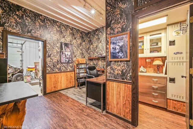 office area featuring light hardwood / wood-style floors and wood walls