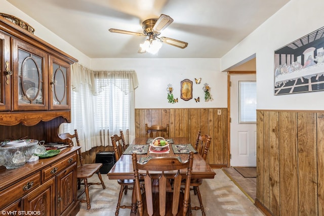 dining room featuring wood walls and ceiling fan