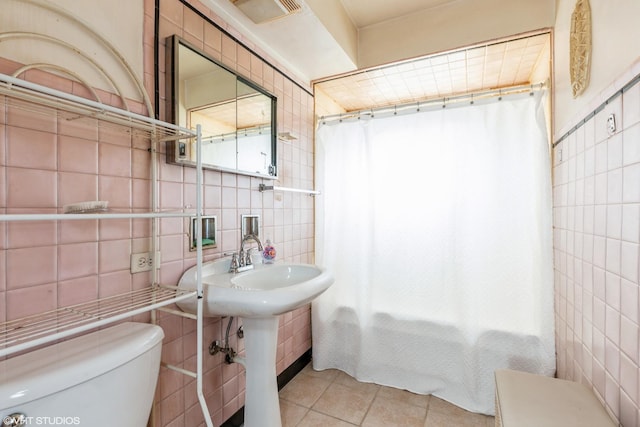 bathroom featuring backsplash, tile patterned floors, a shower with curtain, toilet, and tile walls