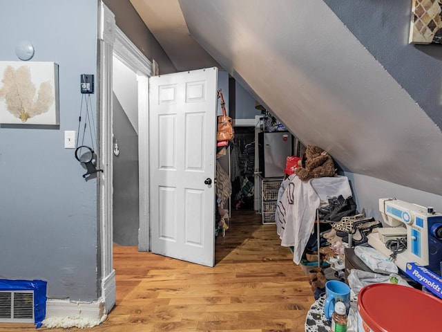 bonus room with light wood-type flooring and vaulted ceiling