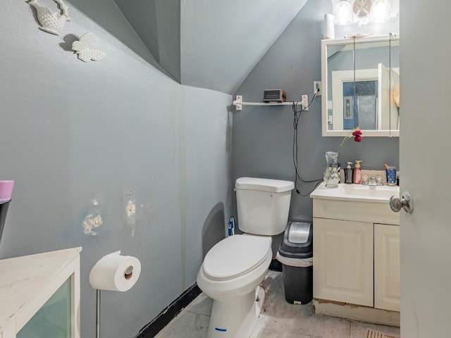 bathroom featuring vanity, toilet, and lofted ceiling