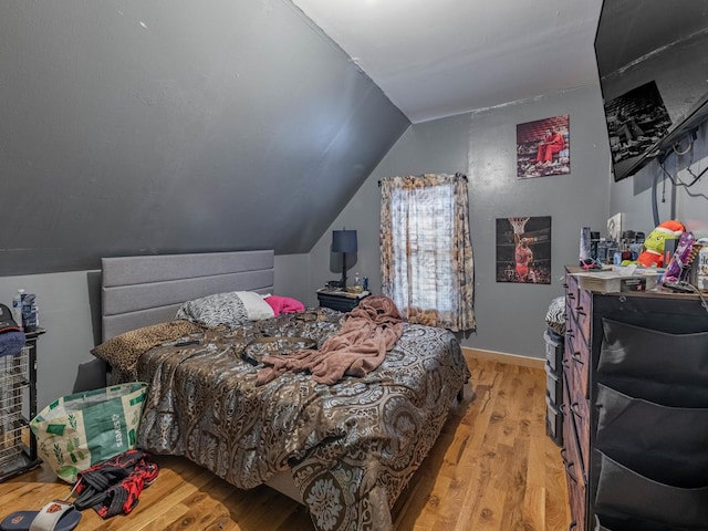 bedroom featuring vaulted ceiling and light hardwood / wood-style flooring