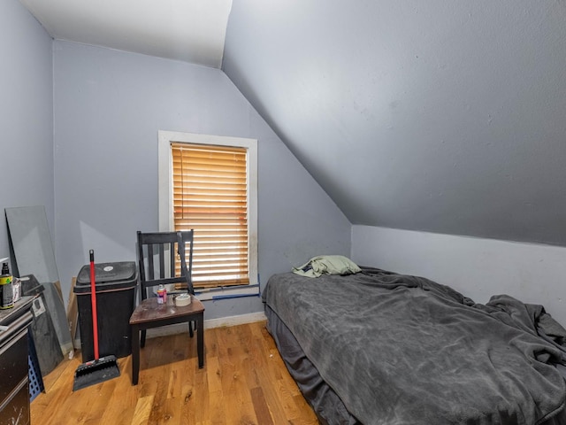 bedroom featuring vaulted ceiling and light hardwood / wood-style flooring