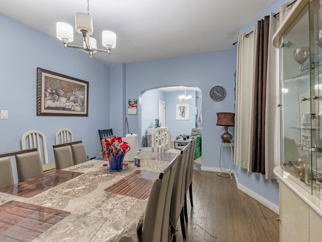 dining space with a notable chandelier and dark hardwood / wood-style flooring