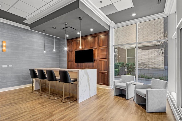 bar with pendant lighting, light hardwood / wood-style floors, and crown molding