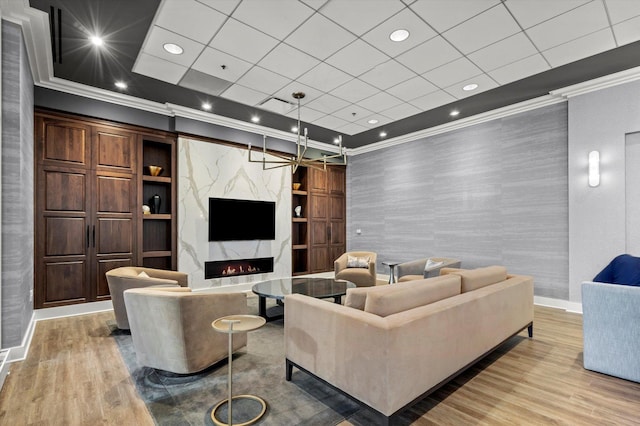 living room featuring ornamental molding, a fireplace, and light hardwood / wood-style flooring