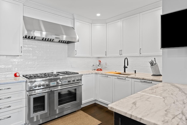 kitchen featuring white cabinets, dark hardwood / wood-style floors, double oven range, and wall chimney range hood