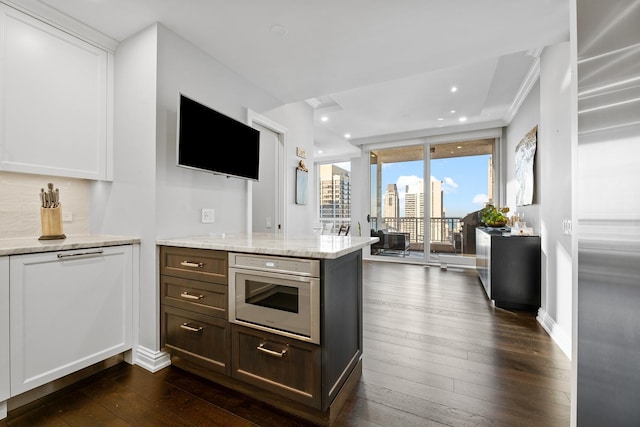 kitchen with white cabinets, oven, and dark hardwood / wood-style flooring